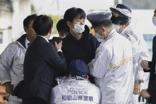 FILE - A man who was later identified as Ryuji Kimura is arrested after what appeared to be a pipe bomb was thrown at Japanese Prime Minister Fumio Kishida during his visit at a port in Wakayama, western Japan, Saturday, April 15, 2023. Kimura, who allegedly threw a pipe bomb at Kishida at a campaign venue, has complained about Japan’s election system and filed a damages suit against the government and criticized the prime minister, according to media reports and his possible social media postings. (Kyodo News via AP, File)