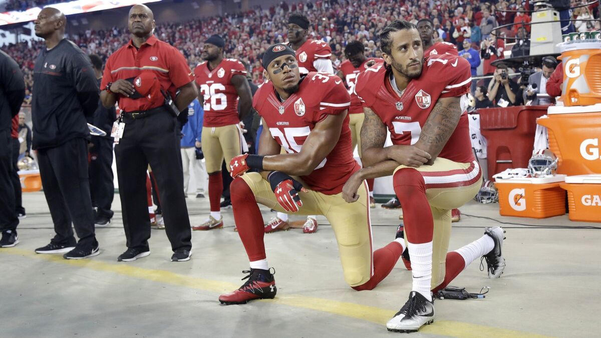 Colin Kaepernick, right, and Eric Reid kneel during the national anthem before a San Francisco 49ers game in 2016.