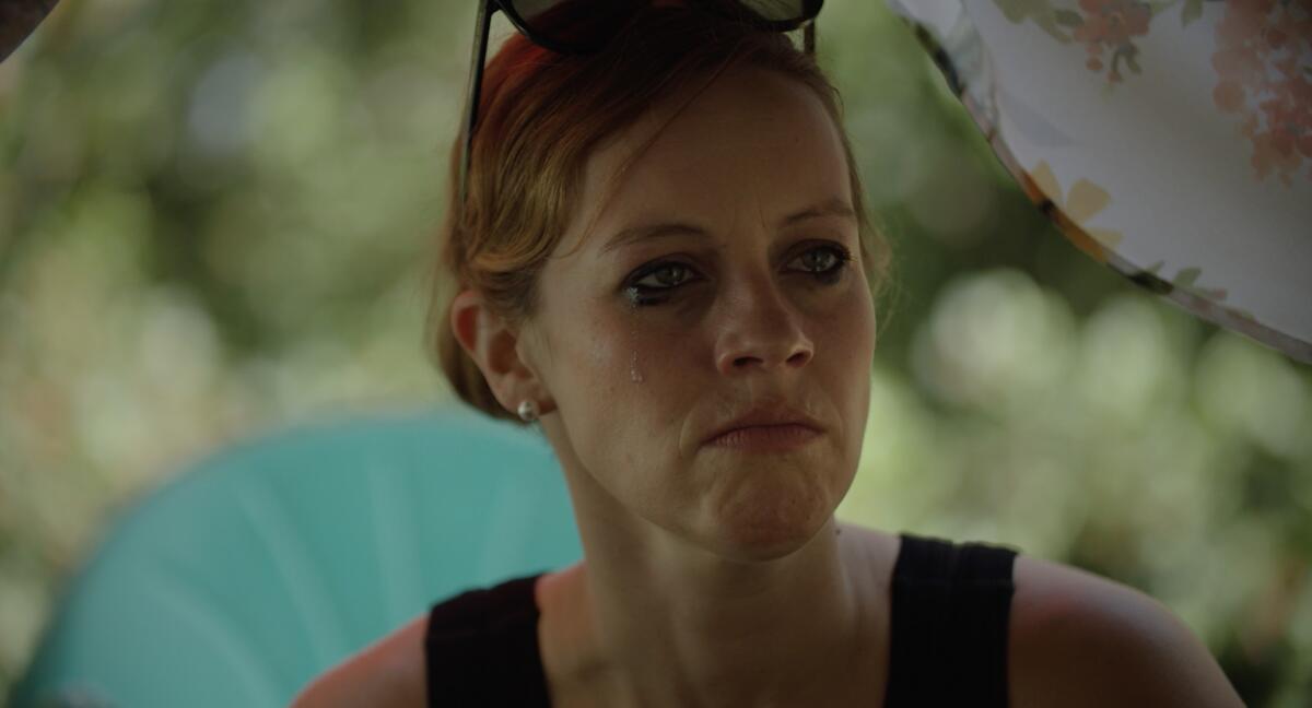 A woman with sunglasses on her head looks off-camera.