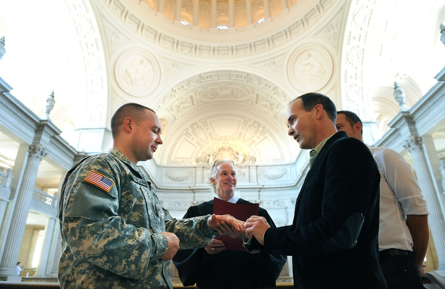 Army Sgt. Michael Potoczniak and his partner Todd Saunders exchange rings during a marriage ceremony at City Hall in San Francisco Saturday.