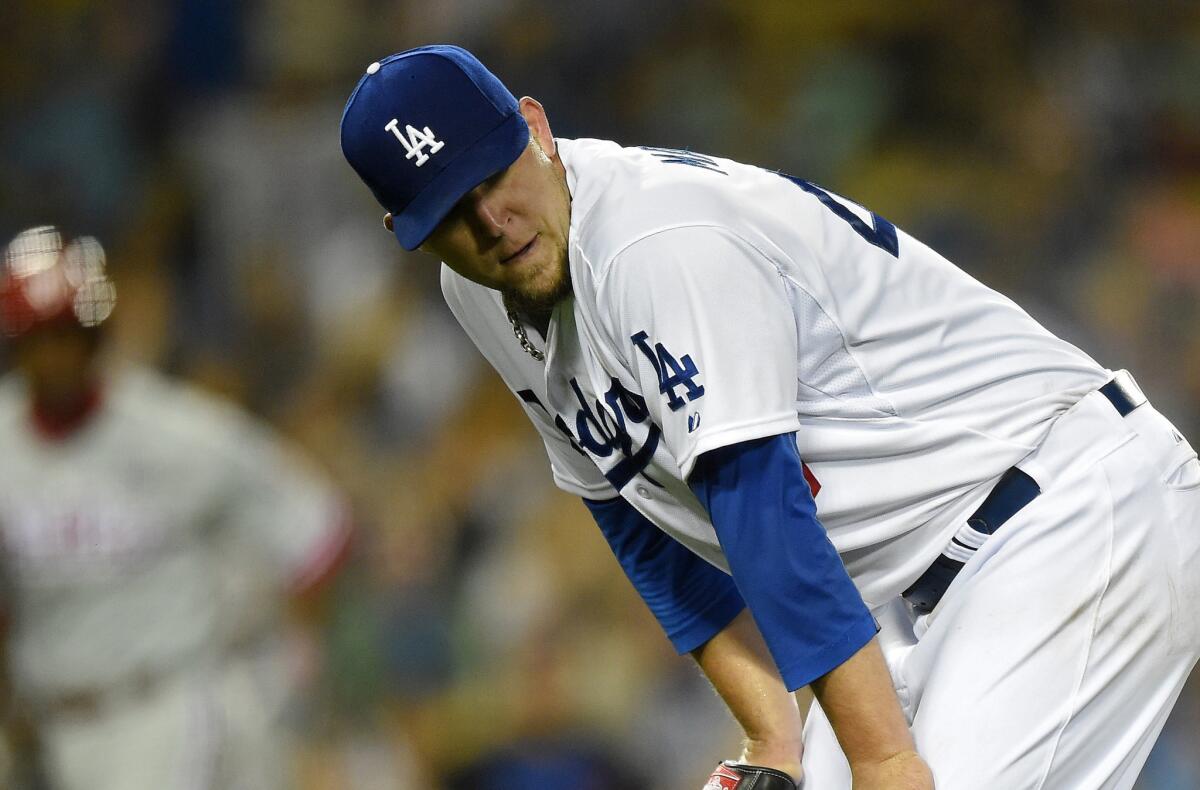 Dodgers starter Paul Maholm looks on after giving up a run on his throwing error to first base during the fifth inning of the Dodgers' 7-0 loss Monday at Dodger Stadium.