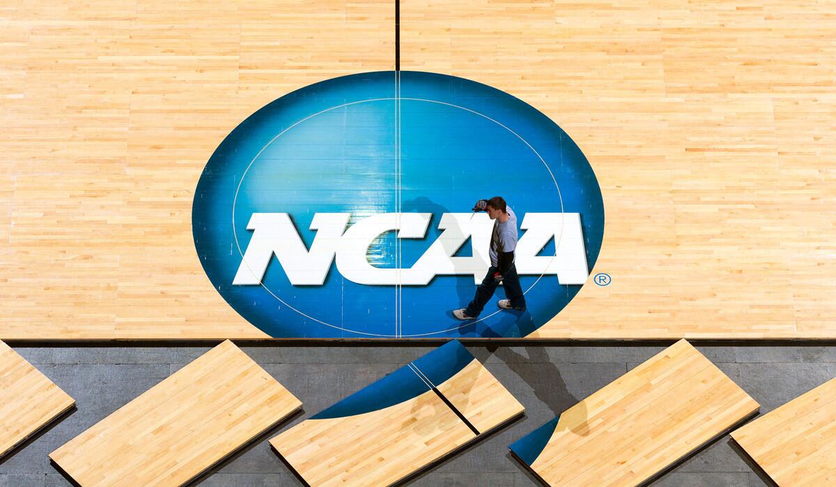 Workers place the basketball court on the floor at the CenturyLink Center in Omaha, Neb. on Tuesday for the second and third rounds of the NCAA Men's Basketball Tournament.