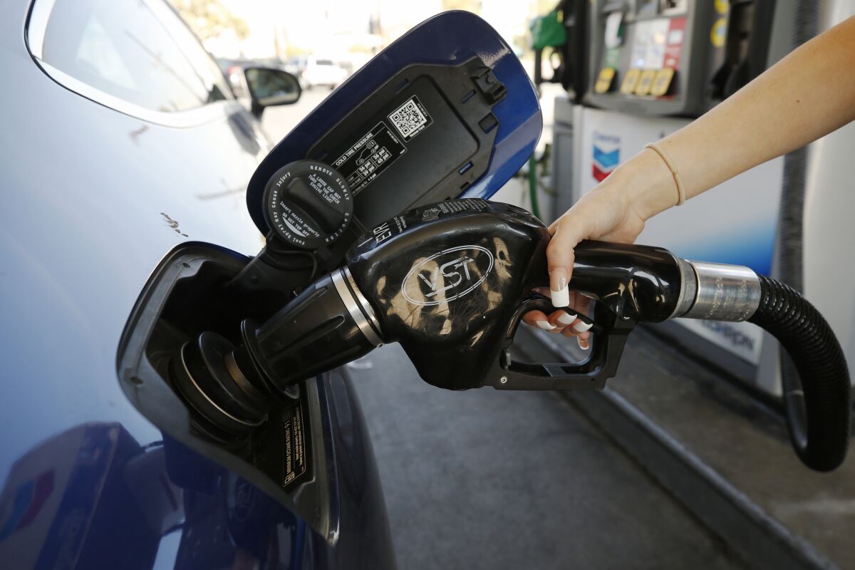 A motorist puts fuel in her gas tank at a Chevron station in downtown Los Angeles.