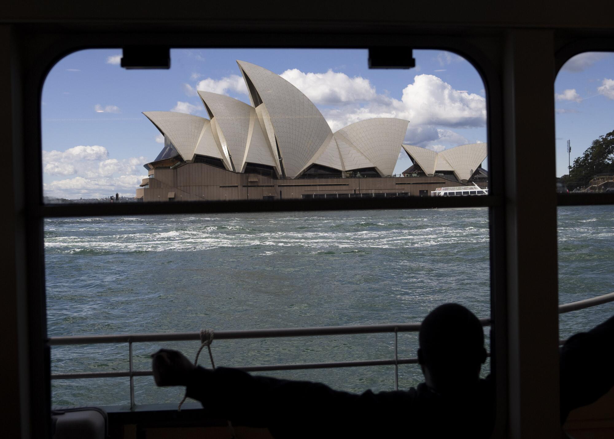一艘船经过悉尼歌剧院。
