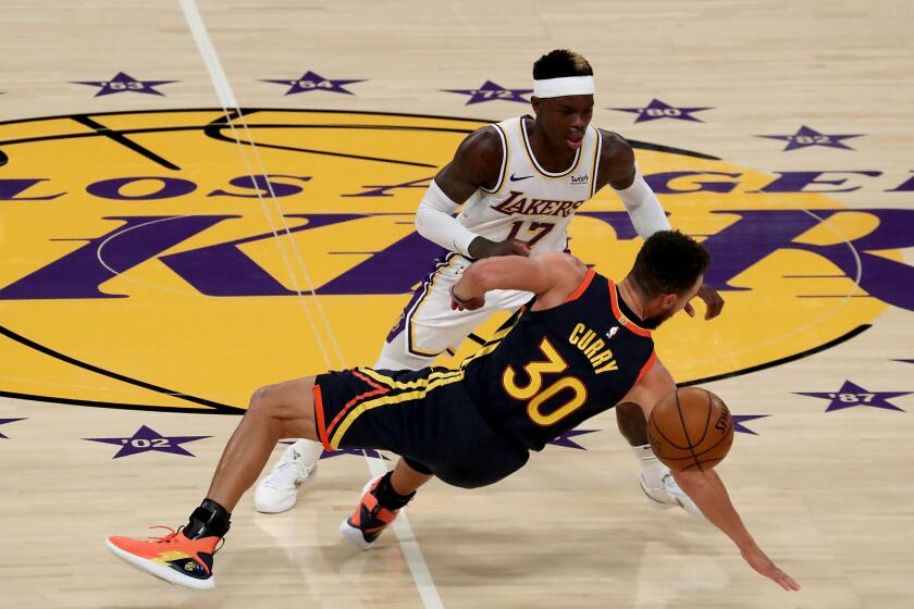 LOS ANGELES, CALIF. - FEB. 28, 2021. Lakers guard Dennis Schroder forces a turnover by Warriors guard Stephen Curry in the first quarter of Sunday night's game, Feb. 28, 2020, at Staples Center in Los Angeles. (Luis Sinco/Los Angeles Times)