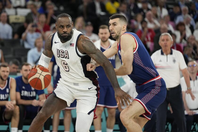 American LeBron James drives past Serbia's Ognjen Dobric during a basketball semifinal 