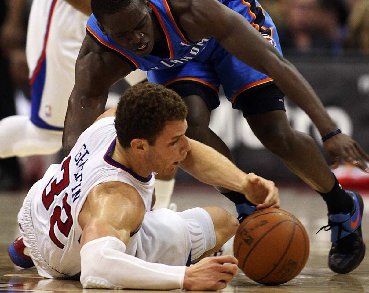 Clippers power forward Blake Griffin hits the court while going for a loose ball against Thunder guard Daequan Cook in the fourth quarter Monday night at Staples Center.