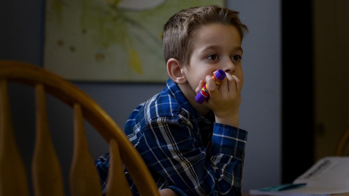 Although most of Paradise's Children's Community Charter School burned to the ground during the Camp fire, the learning has continued for third- graders at the home of teacher Sheri Eichar of Chico. Rowan Reynolds, 8, listens during math class at the kitchen table.