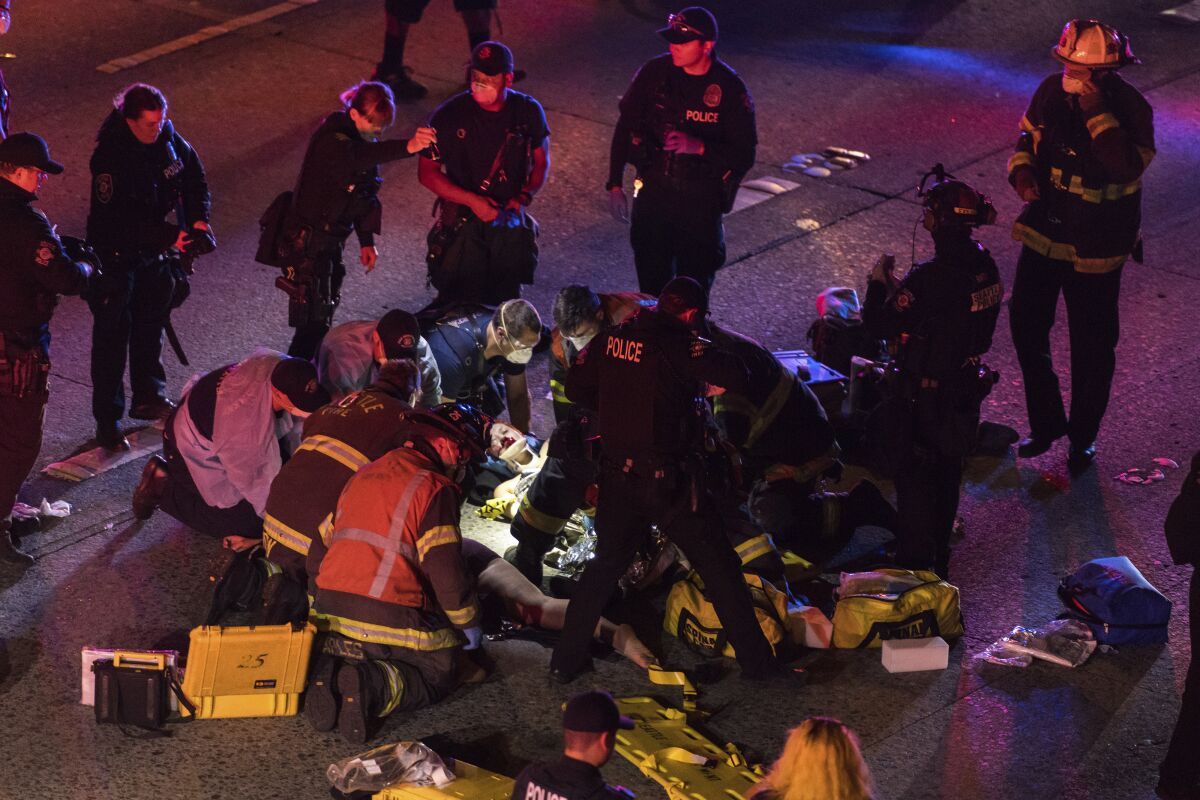 Emergency workers tend to injured people after a driver sped through protesters on Interstate 5 in Seattle early Saturday.