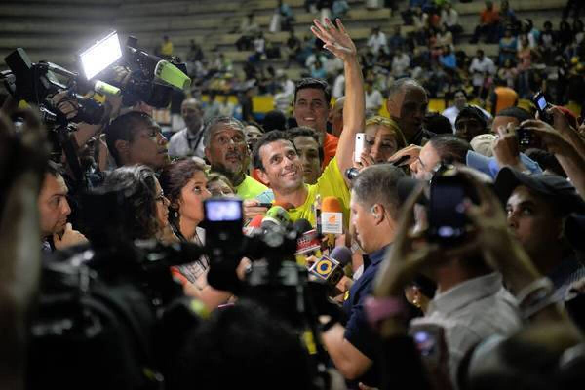 Venezuelan opposition candidate Henrique Capriles is surrounded by journalists Friday after playing basketball during a nonpolitical event in Caracas. Voters will head to the polls Sunday.