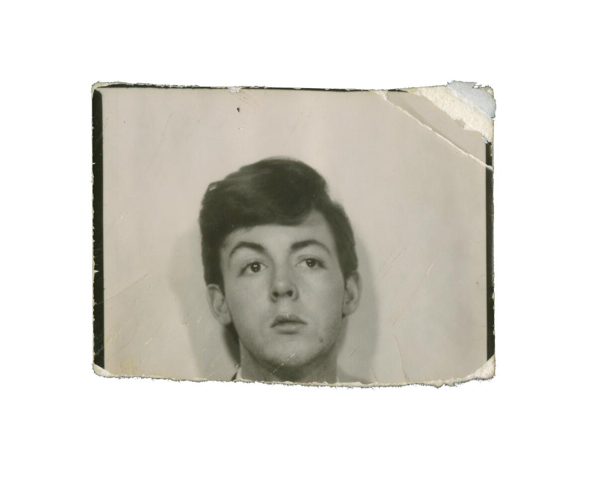 A passport-style photograph of Paul McCartney from the late 1950s.