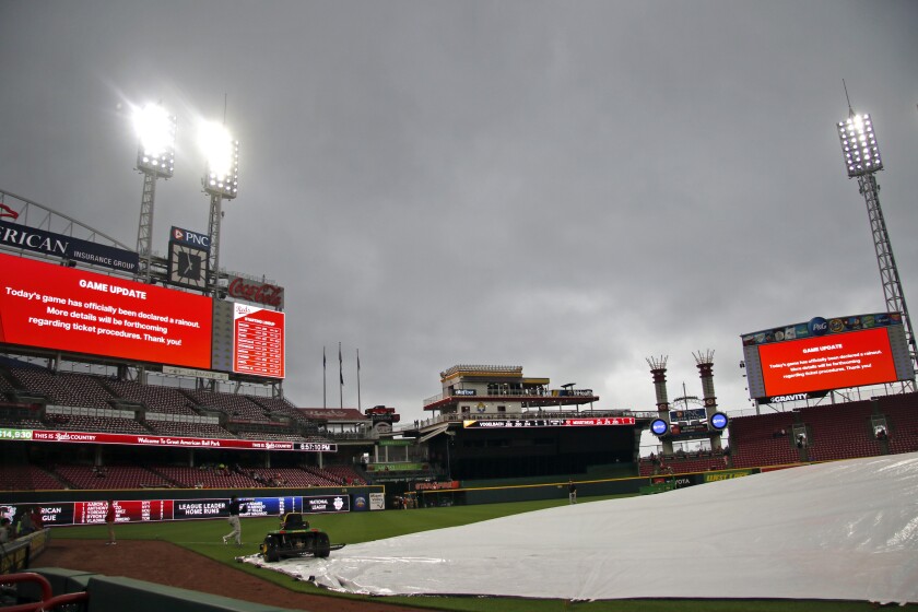 The scoreboards announce that the Pittsburgh Pirates against the Cincinnati Reds baseball game has been officially declared a rainout Friday, May 6, 2022, in Cincinnati. (AP Photo/Tom E. Puskar)