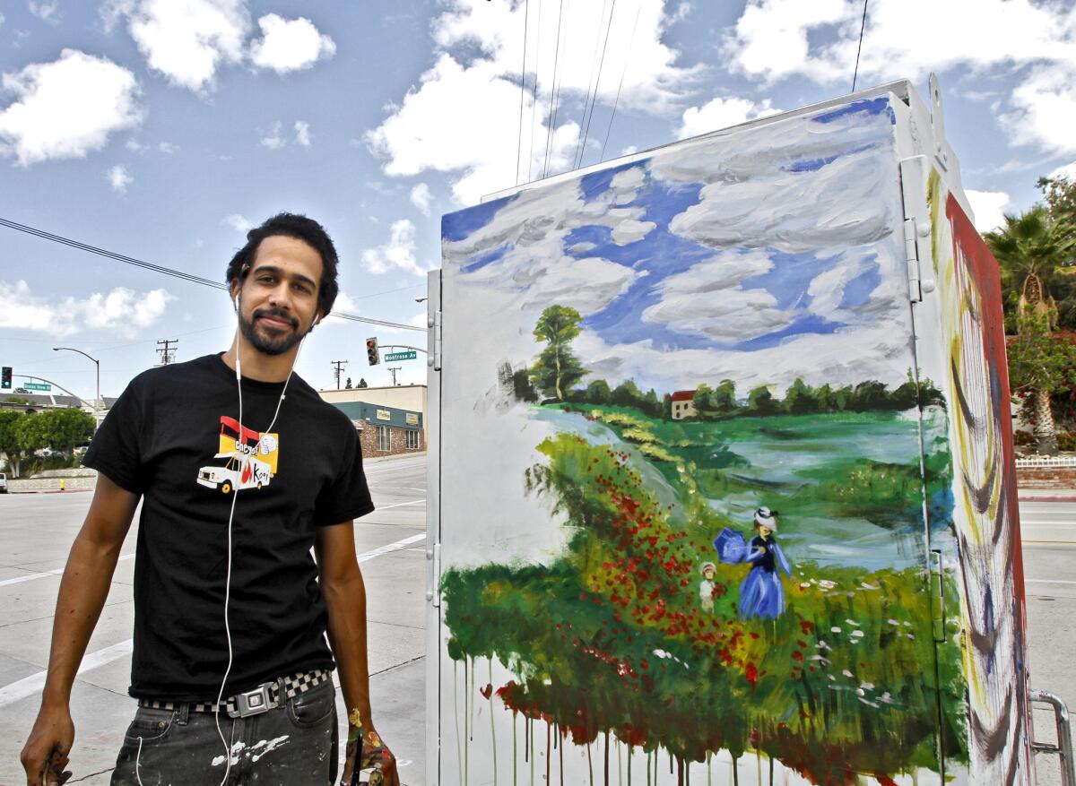 Zach Brown, of Highland Park, shows off his artwork on a utility box at Ramsdell and Honolulu avenues as part of the city of Glendale's Beyond the Box program on Saturday, Oct. 25, 2014. The city is now looking to hire a consultant to put together a public art master plan to includes projects like the Beyond the Box program.