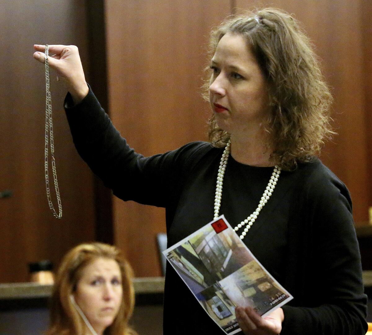 A woman speaks while standing in a courtroom 