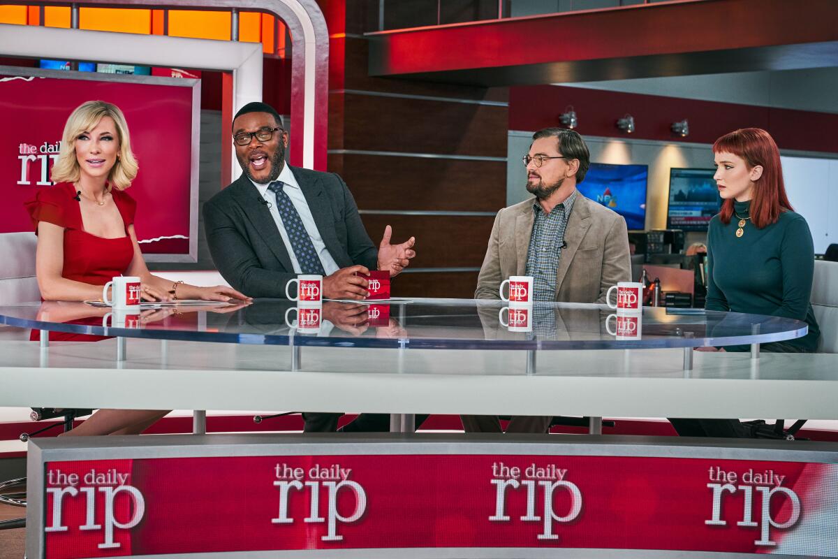 Four people sitting at a TV news desk in “Don't Look Up” (2021)