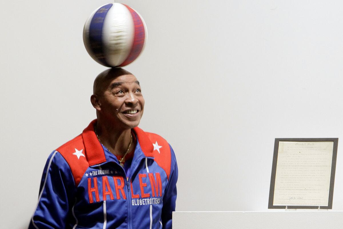 Curly Neal spins a ball on his head at an event in December 2010.