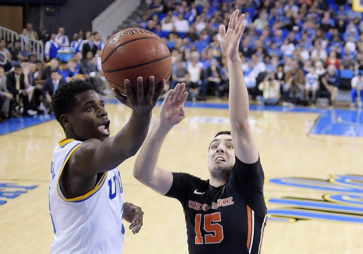 UCLA guard Aaron Holiday, left, shoots as Oregon State guard Tanner Sanders defends during the first half on Feb. 12.