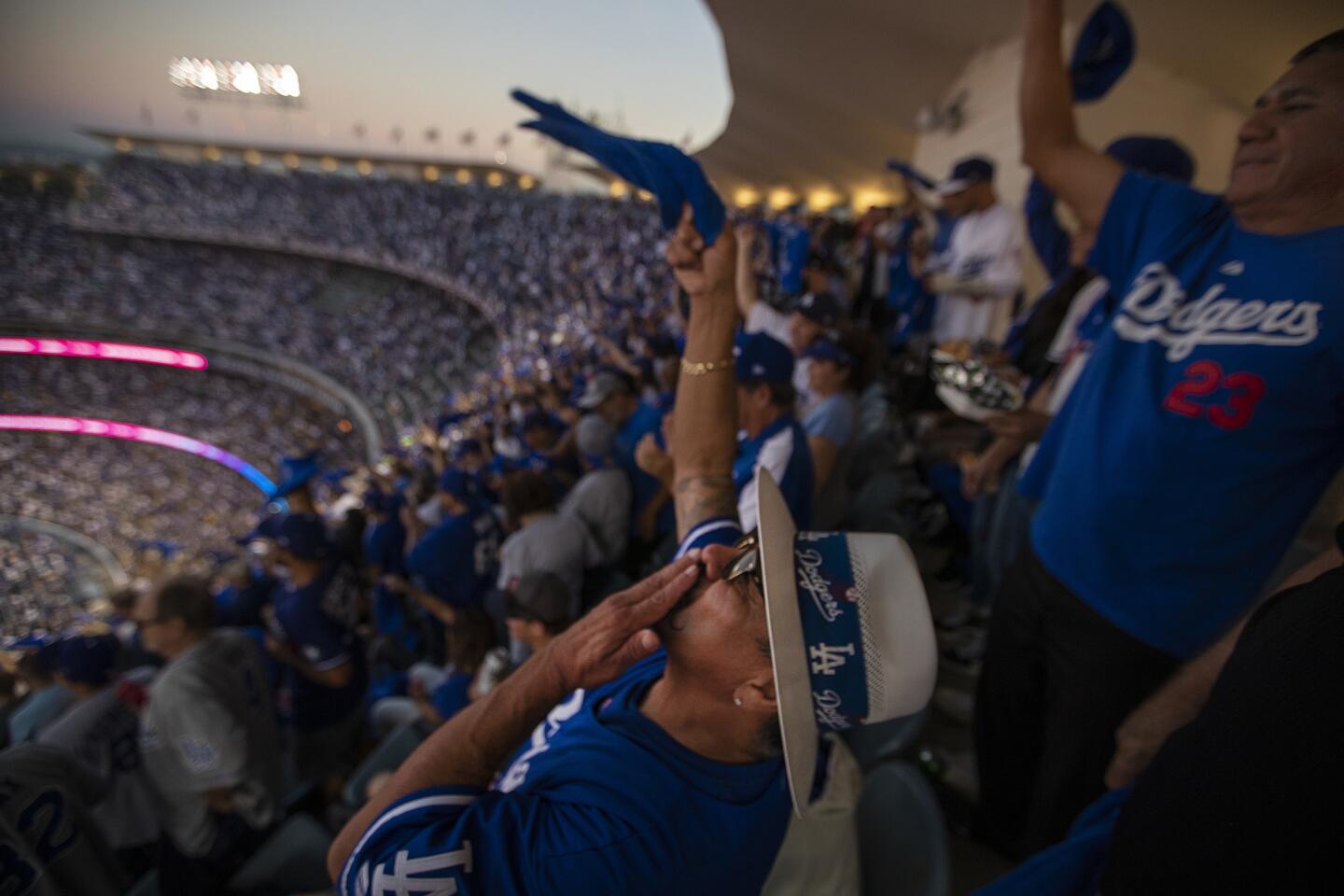 Dodgers fan Jesus Rubio II, center, and his son, Jesus Rubio III, of Lytle Creek, (not visible) erupt with celebration as Dodgers outfielder Joc Pederson hits a home run in the third inning.