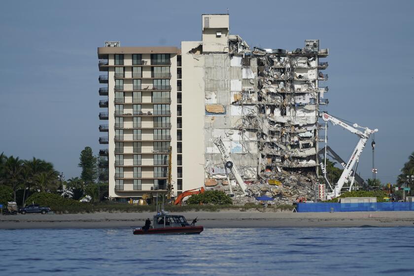 A coast guard boat patrols in front of the partially collapsed Champlain Towers South condo building, ahead of a planned visit to the site by President Joe Biden, on Thursday, July 1, 2021, in Surfside, Fla. Search and rescue workers, who have had to contend with summer rainstorms, fires within the debris, and the threat of collapse from the still standing portion of the building, were not visible atop the rubble on Thursday morning, as scores of people remain missing one week after the collapse.(AP Photo/Mark Humphrey)