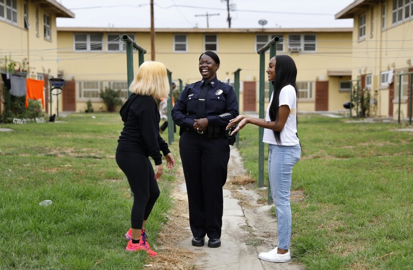 Emada Tingirides, center, chats with Petra Avelar, 18, left, and Meah Watson, 18, right, at Nickerson Gardens in Watts