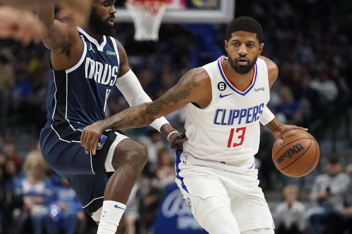 Clippers guard Paul George, right, controls the ball in front of Dallas Mavericks forward Tim Hardaway Jr.