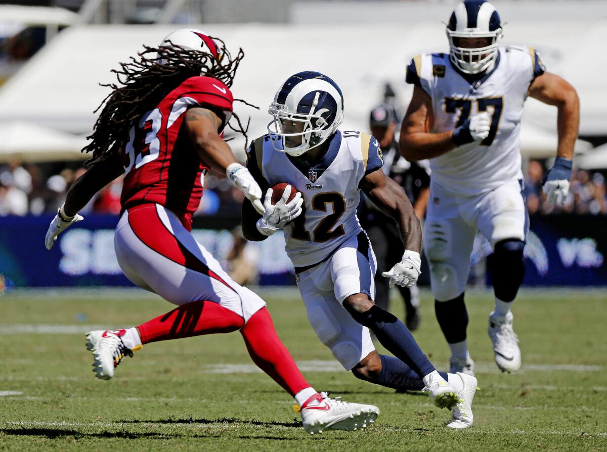 Rams wide receiver Brandin Cooks (12) heads upfield trying to avoid the tackle of Arizona Cardinals defensive back Tre Boston (33) in the first half at the Los Angeles Memorial Coliseum on Sunday.