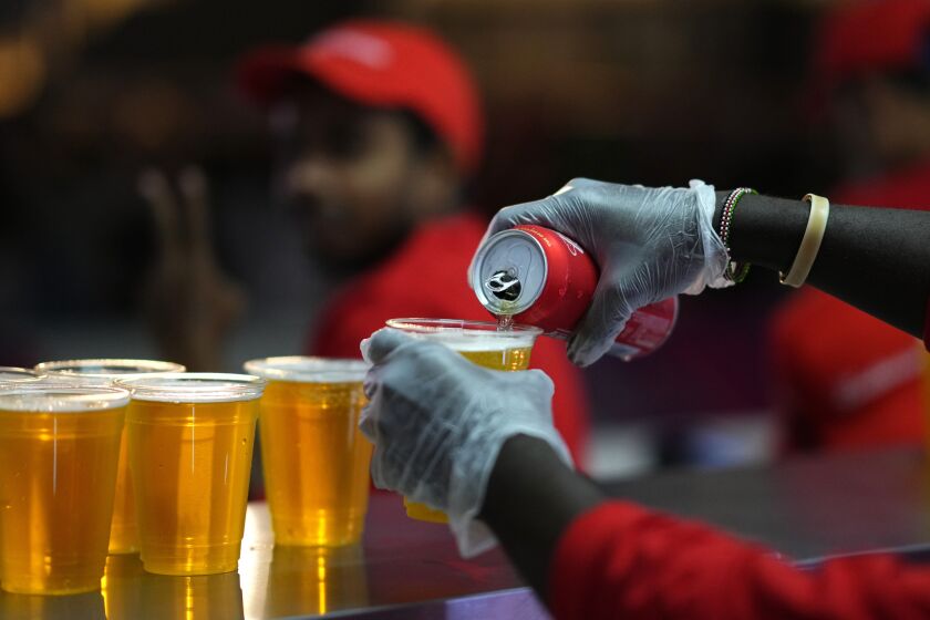 FILE - Staff member pours a beer at a fan zone ahead of the FIFA World Cup, in Doha, Qatar Saturday, Nov. 19, 2022. The last-minute decision to ban the sale of beer at World Cup stadiums in Qatar is the latest example of some the tensions that have played out ahead of the tournament. Qatari officials have for long said they were eager to welcome everybody but that visitors should also respect their culture and traditions. (AP Photo/Petr Josek)