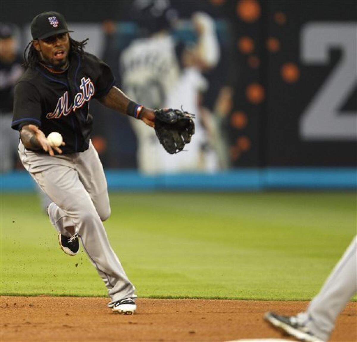 New York Mets Jose Reyes throws to first base while leaping over a