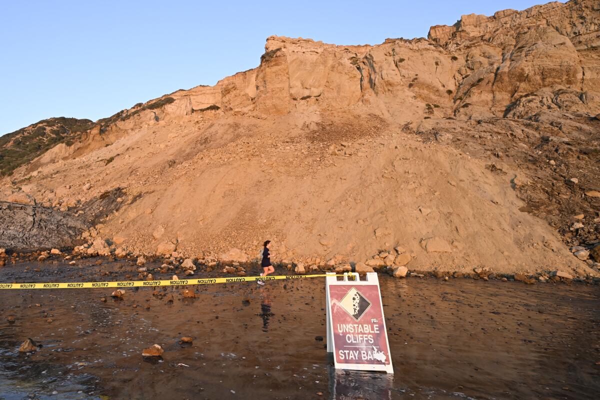 A runner passes a collapsed bluff at Black's Beach on Jan. 20.