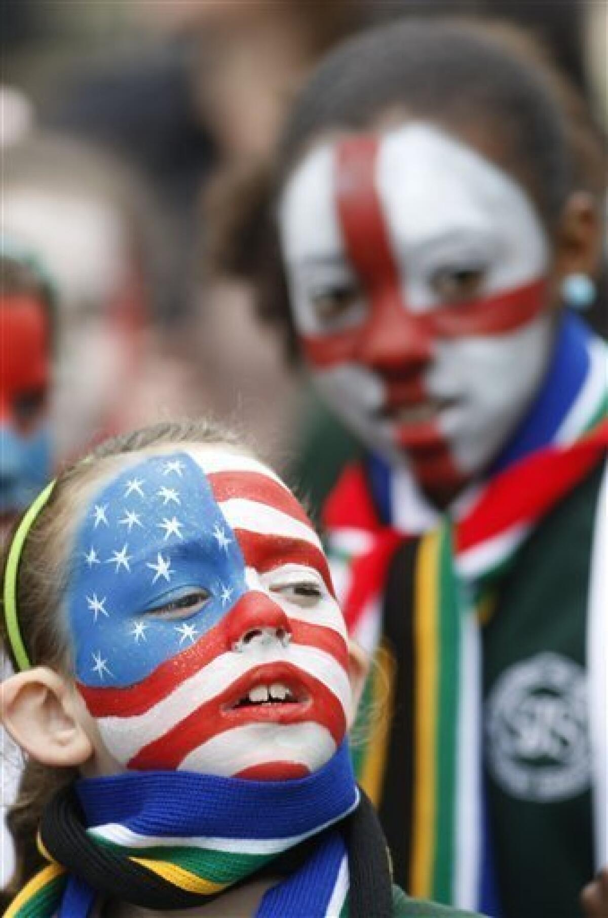 Pupils from St Joseph's Primary School with their faces painted with the country flags, of U.S., left, and England, wait for a special event to mark the start of South Africa World Cup Soccer at Trafalgar Square in London and to show support for England's bid to host the 2018 FIFA World Cup, Friday, June 11, 2010. (AP Photo/Sang Tan)