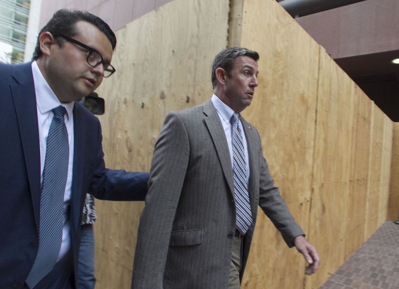 Rep. Duncan Hunter Jr., right, leaves after he appeared in Federal Court in San Diego with his attorney Gregory Vega on Monday, Sept. 24 for a status hearing on his case.