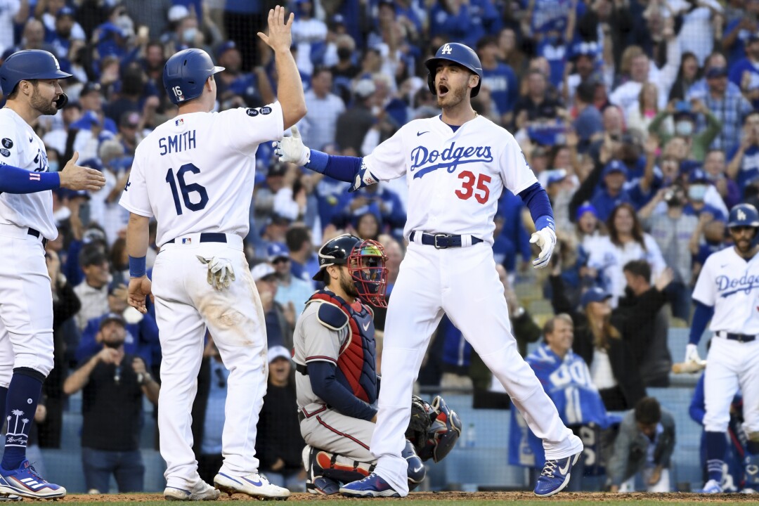 Los Angeles Dodgers' Cody Bellinger, right, celebrates with Will Smith and AJ Pollock.