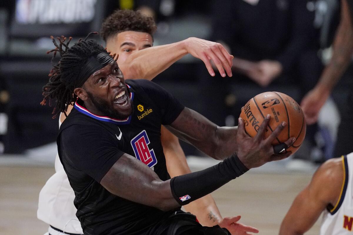 Clippers center Montrezl Harrell drives to the basket against Nuggets forward Michael Porter Jr. on Thursday.