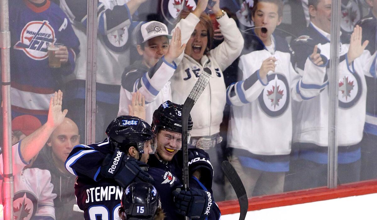 Jets fans join the revelry as Lee Stempniak celebrates a goal with teammate Andrew Copp on April 11.