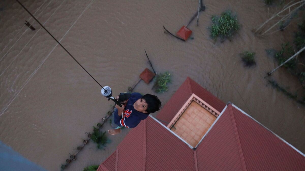 A stranded flood victim is airlifted to safety in Paravoor in the Indian state of Kerala on Aug. 18, 2018.