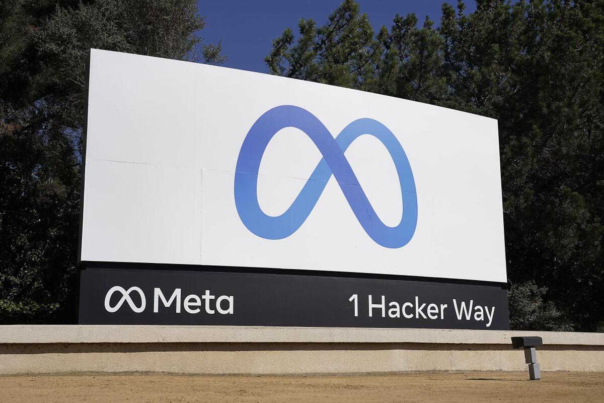Trees surrounding a sign that shows Meta's logo and the address 1 Hacker Way