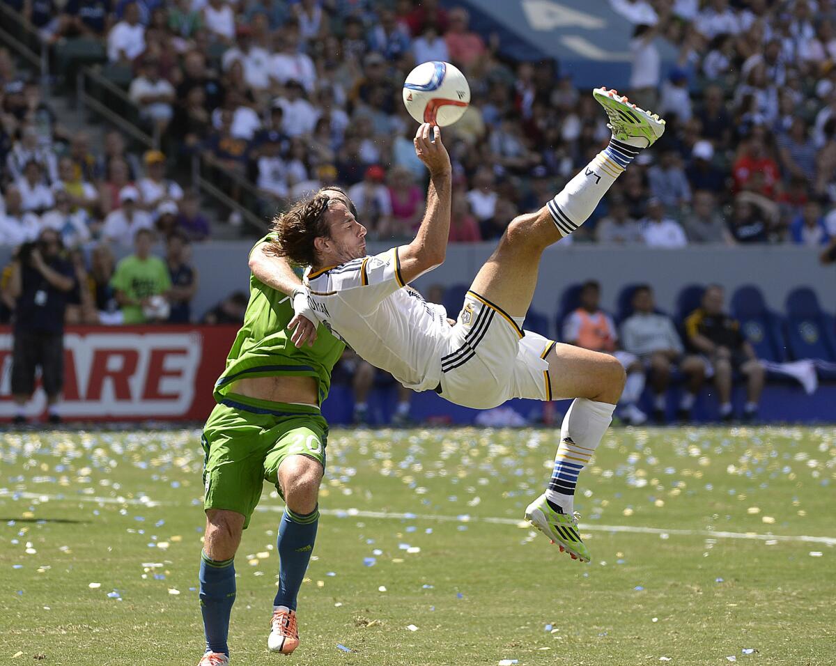 Alan Gordon, right, of the Galaxy makes an over-the- head kick against the Seattle Sounders on Aug. 9 at the StubHub Center in Carson.