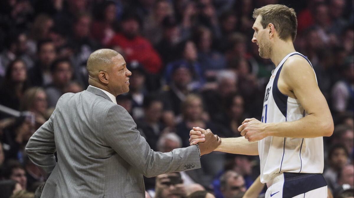 Clippers coach Doc Rivers greets Mavericks forward Dirk Nowitzki during a break in the action at Staples Center.