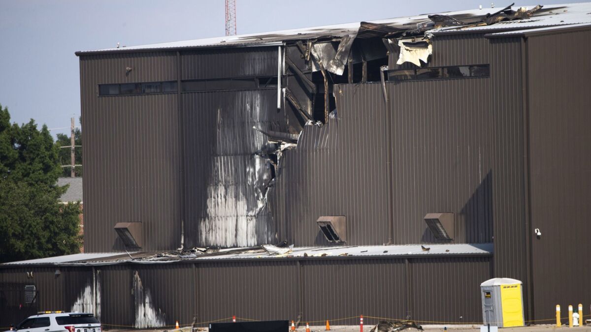 Damage is seen at a hangar after a twin-engine plane crashed into the building at an airport in Addison, Texas, on Sunday.