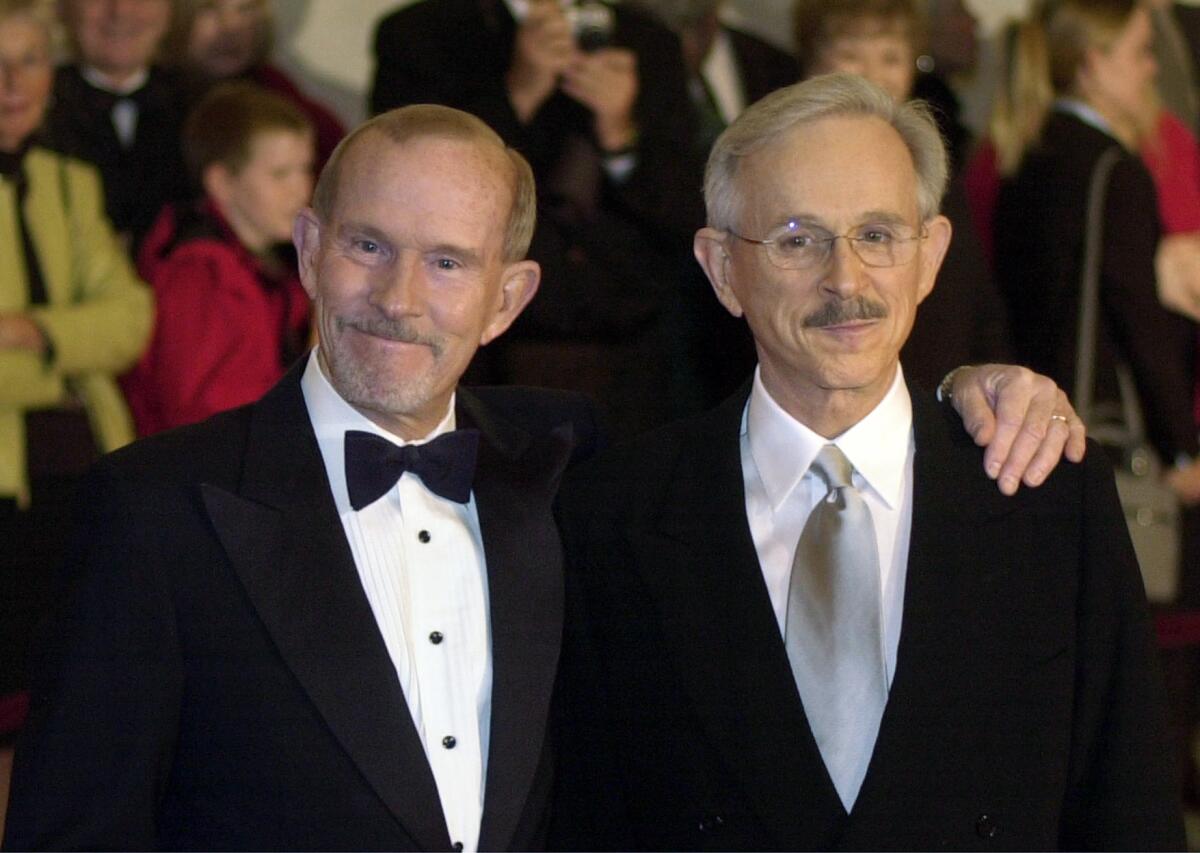 Tom and Dick Smothers pose together in formalwear