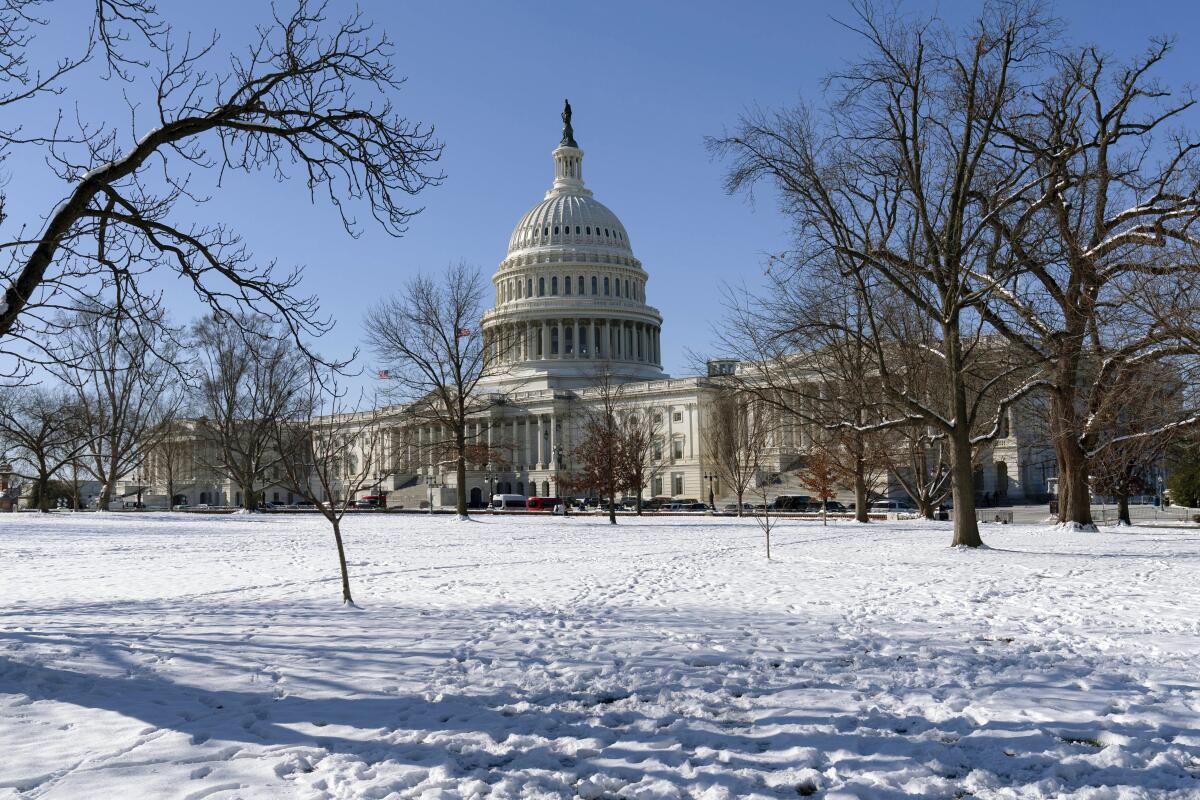 An exterior view of the U.S. Capitol on a sunny day, despite lots of snow on the ground