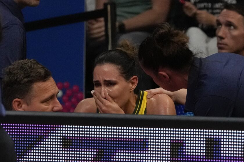 Australia's Bec Allen is attended to by medical staff after an injury during their game at the women's Basketball World Cup against Serbia in Sydney, Australia, Sunday, Sept. 25, 2022. (AP Photo/Mark Baker)
