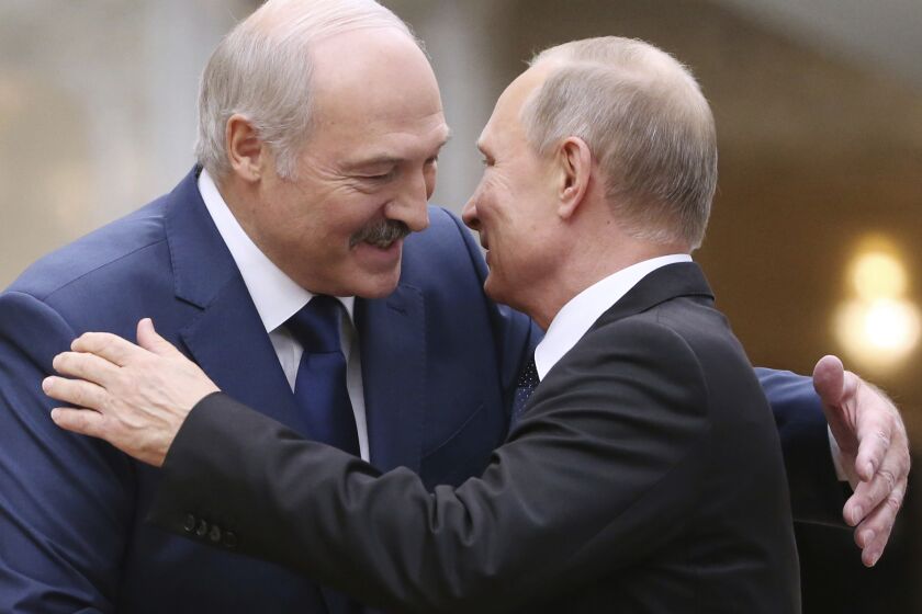 FILE- In this file photo taken on Thursday, Nov. 30, 2017, Belarusian President Alexander Lukashenko, left, greets Russian President Vladimir Putin during the Collective Security Council of the Collective Security Treaty Organization (CSTO) summit in Minsk, Belarus. Putin warned that he stands ready to send police to Belarus if protests there turn violent, but added in an interview broadcast Thursday that there is no such need now and voiced hope for stabilizing the situation in the neighboring country. (Tatyana Zenkovich, Pool Photo via AP, File)