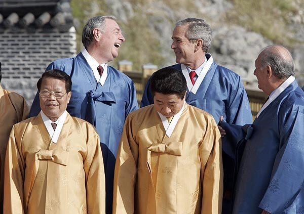 Wearing traditional durumagi silk robes, U.S. President George W. Bush, top row right, shares a laugh with Canada's Prime Minister Paul Martin, top row left, as Vietnam's President Tran Duc Luong, South Korea's President Roh Moo-hyun, and Chile's President Ricardo Lagos stand nearby during the official Asia-Pacific Economic Cooperation group photo in Busan, South Korea, in 2005.