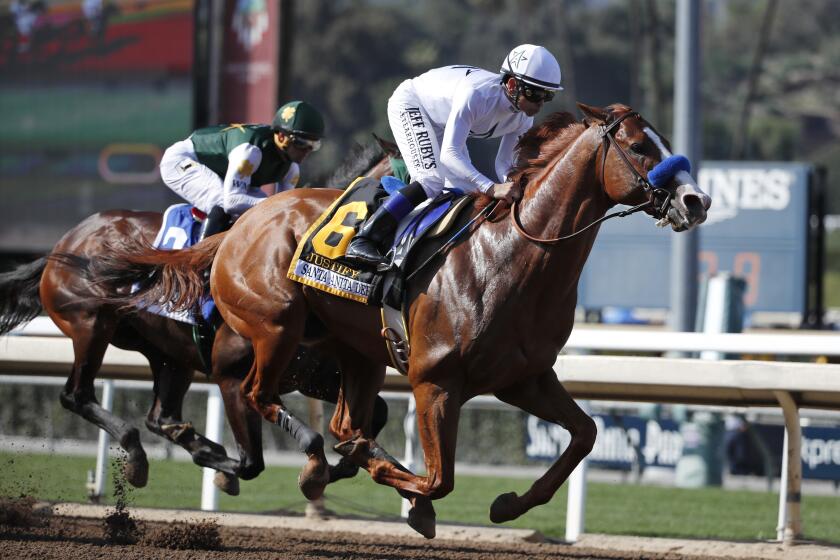 FILE - In this April 7, 2018, file photo, Justify, ridden by Mike Smith, gallops past Bolt d'Oro, left, with jockey Javier Castellano, during the Santa Anita Derby horse race at Santa Anita in Arcadia, Calif. Justify won the race, and Bolt d'Oro came in second. The New York Times says Justify won the 2018 Triple Crown after a failed postrace drug test at Santa Anita that could have kept the horse out of the Kentucky Derby. The newspaper reported Wednesday, Sept. 11, 2019, that Bob Baffert-trained Justify tested positive for the drug scopolamine after winning the Santa Anita Derby. Justify went on to win the Derby and took the Preakness and Belmont stakes to complete the Triple Crown. (AP Photo/Jae C. Hong, File)