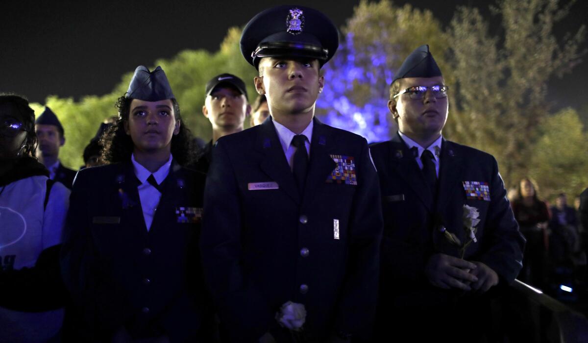Members of the ROTC attend a candlelight vigil Sunday night at Central Park.