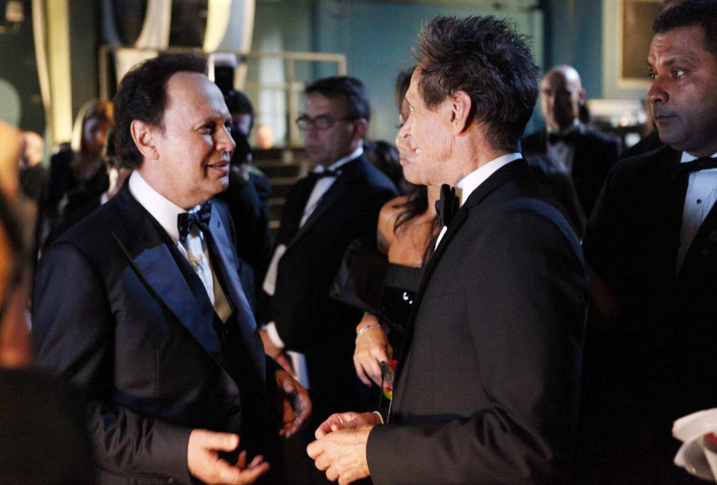 The Oscar host, left, and the Academy Awards producer talk offstage during the telecast.