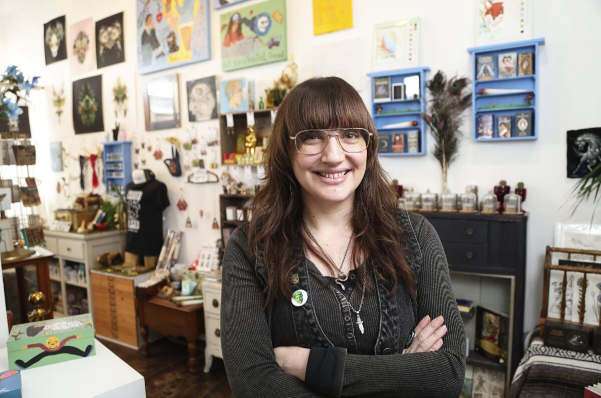 A woman with bangs and glasses standing in a quirky art store