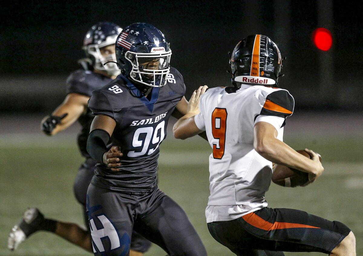 Newport Harbor defensive lineman Eric Gage pressures Huntington Beach's Brady Edmunds during Friday night's game.