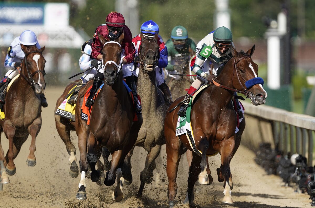 Florent Geroux rides Shedaresthedevil, second left, and John Velazquez rides Gamine, right, going into the first turn during the 146th running of the Kentucky Oaks at Churchill Downs, Friday, Sept. 4, 2020, in Louisville, Ky. (AP Photo/Mark Humphrey)